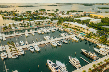 Aerial view of Hilton Key West Resort & Marina on Stock Island showing marina with yachts, waterfront buildings, and palm trees